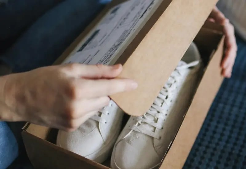 Sapatos novos sendo abertos na caixa.